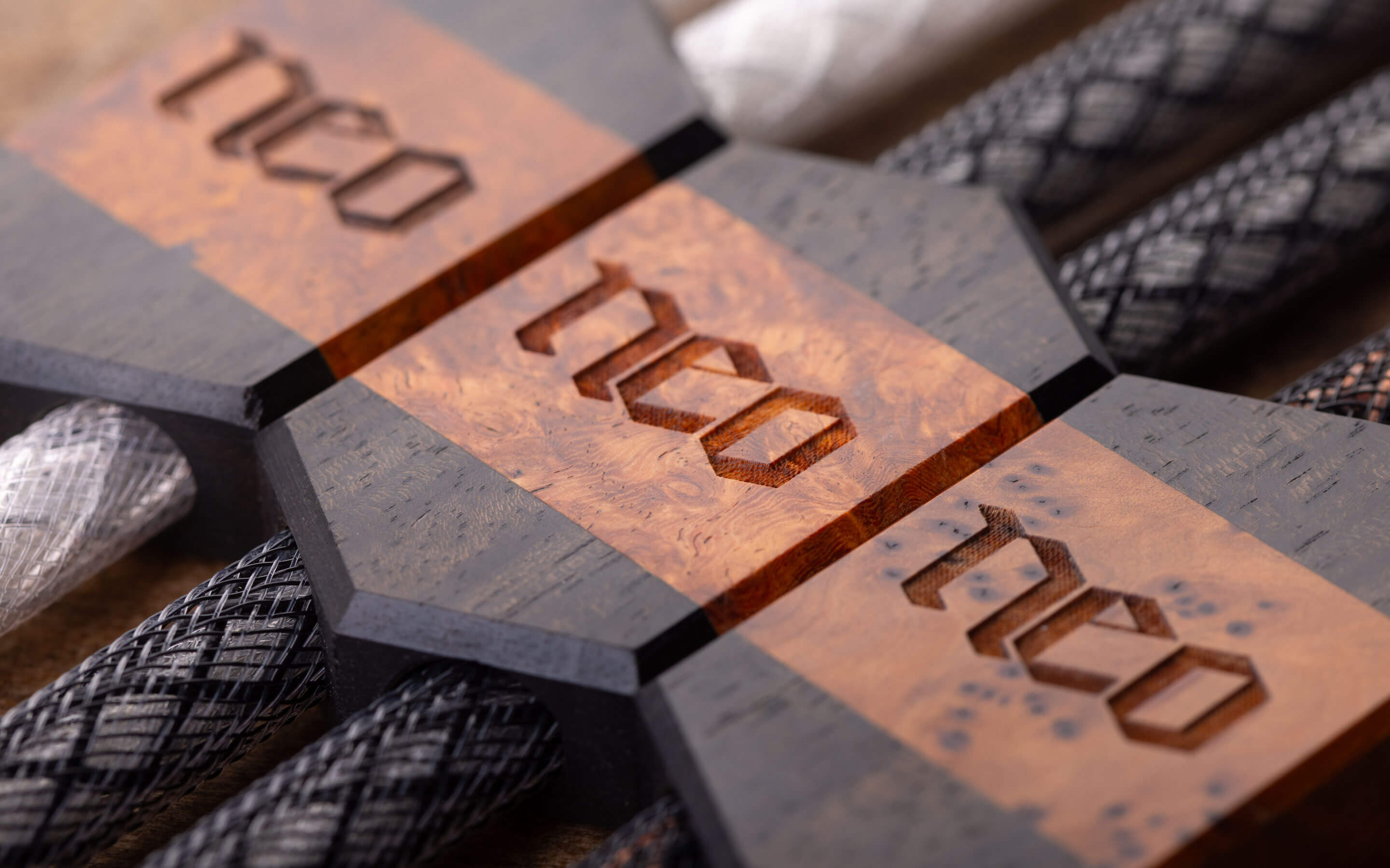 Close up of Neo cable with engraved wood block featuring NEO logo.